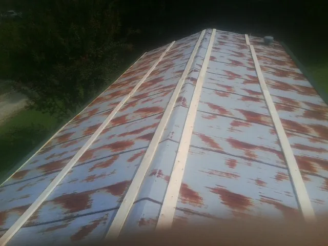 Rusted metal roof panels with new wood purlins before replacement — Storm Damage Roof Repair in Solon by Roofing Brothers